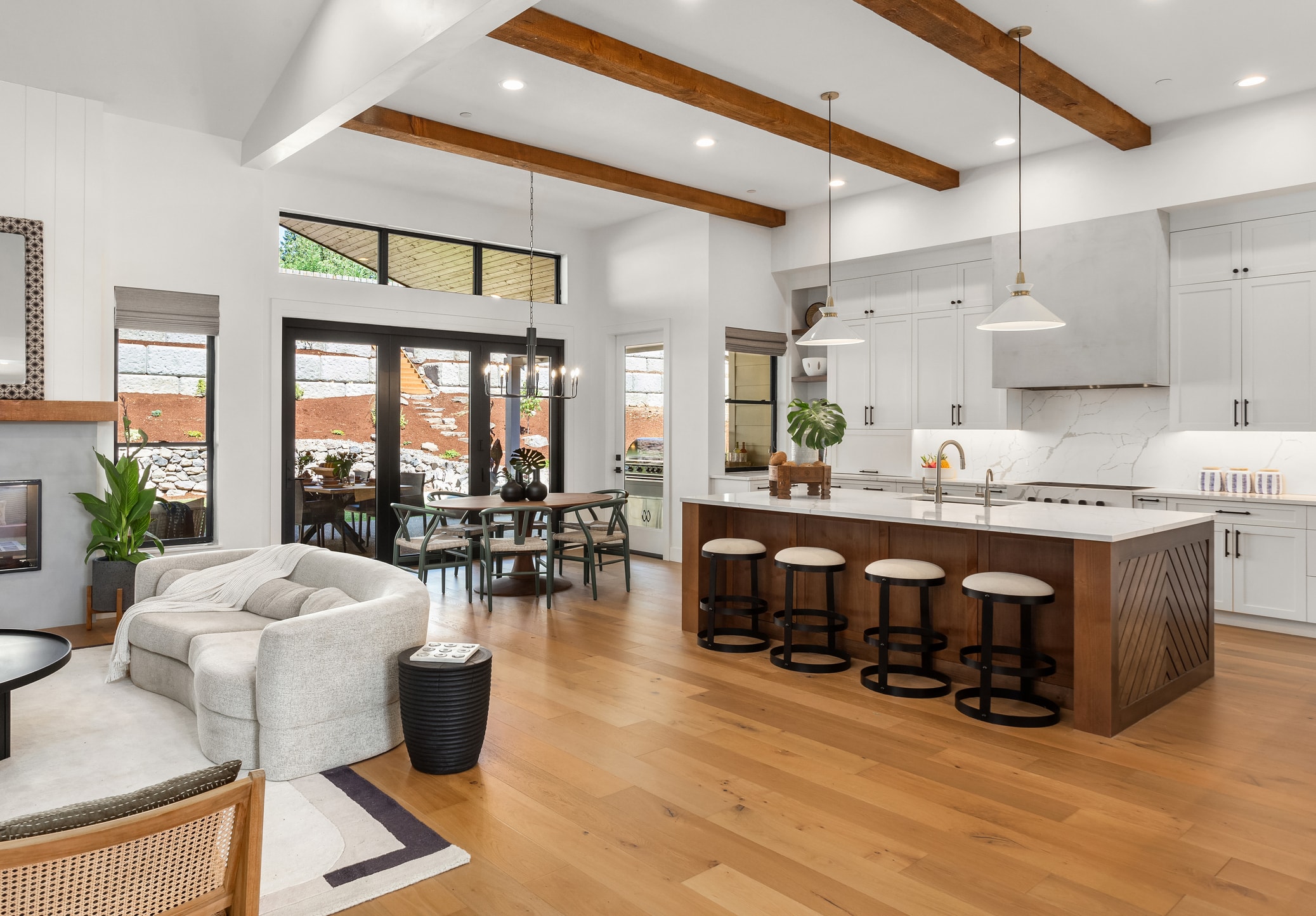 Beautiful kitchen with white cabinetry and black hardware with a wooden island.