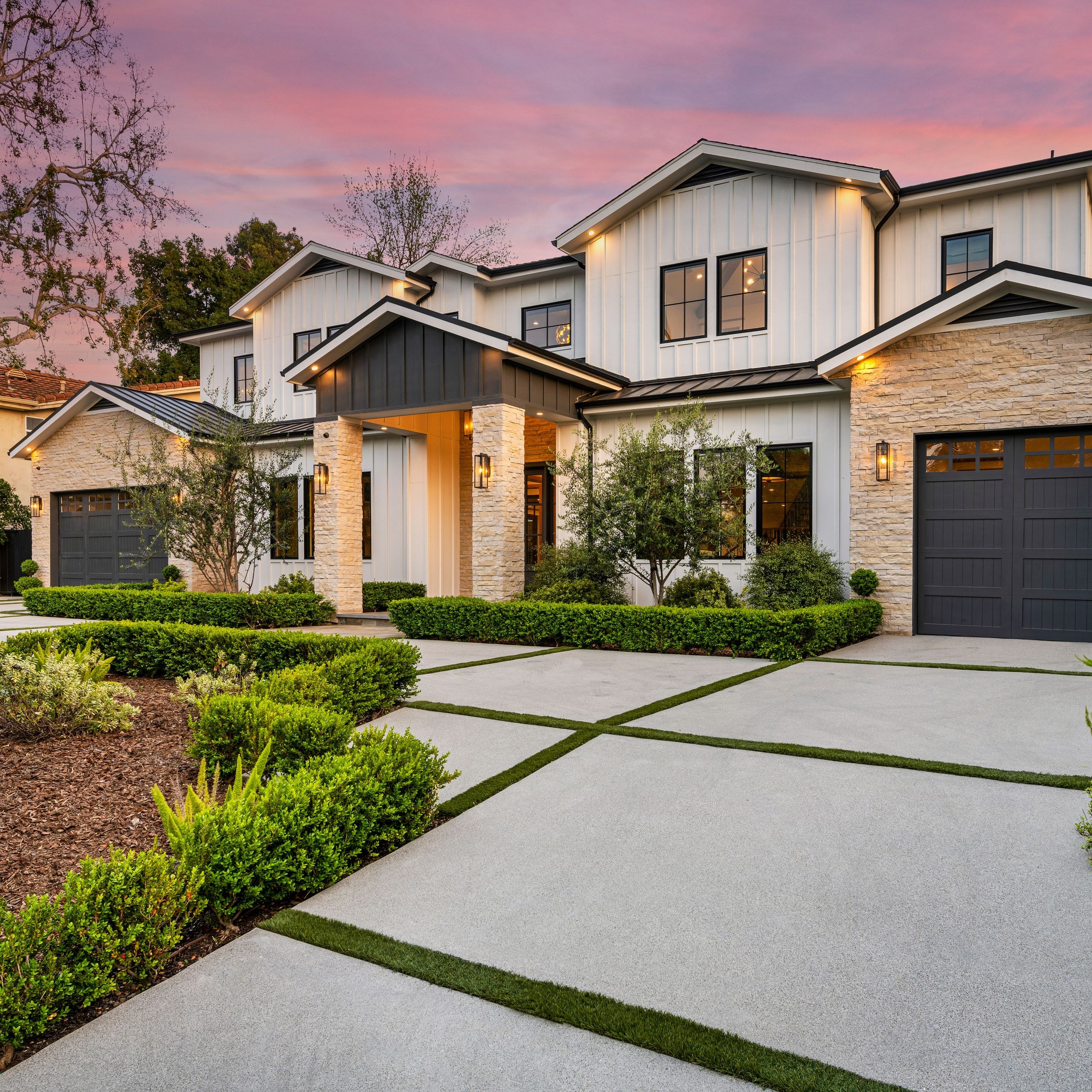 Beautiful large home with elaborately paved driveway at twilight.